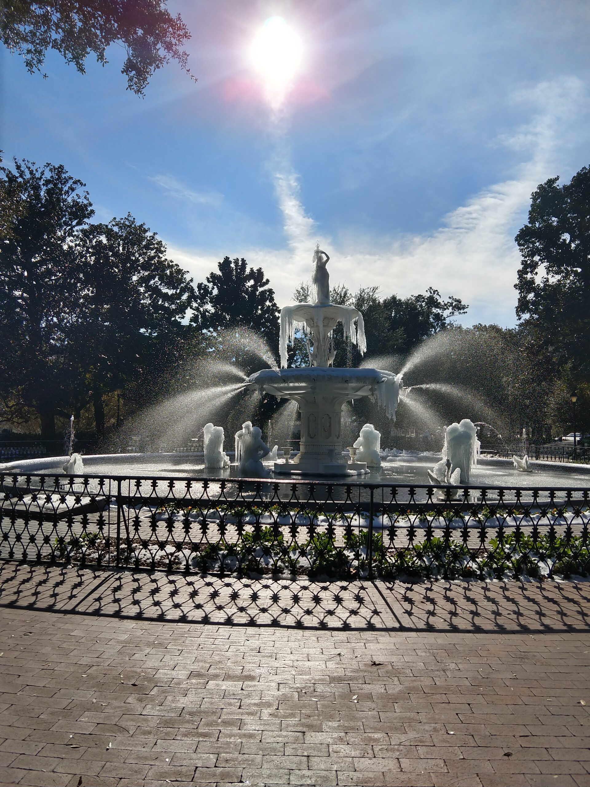 Forsyth Park fountain in full operation during the January 2018 Savannah freeze — all water jets still firing while the entire fountain structure is coated in ice and icicles