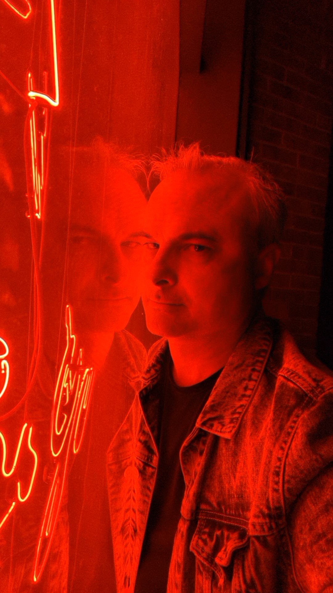 Patrick Burns bathed in red neon light at a Savannah bar at night