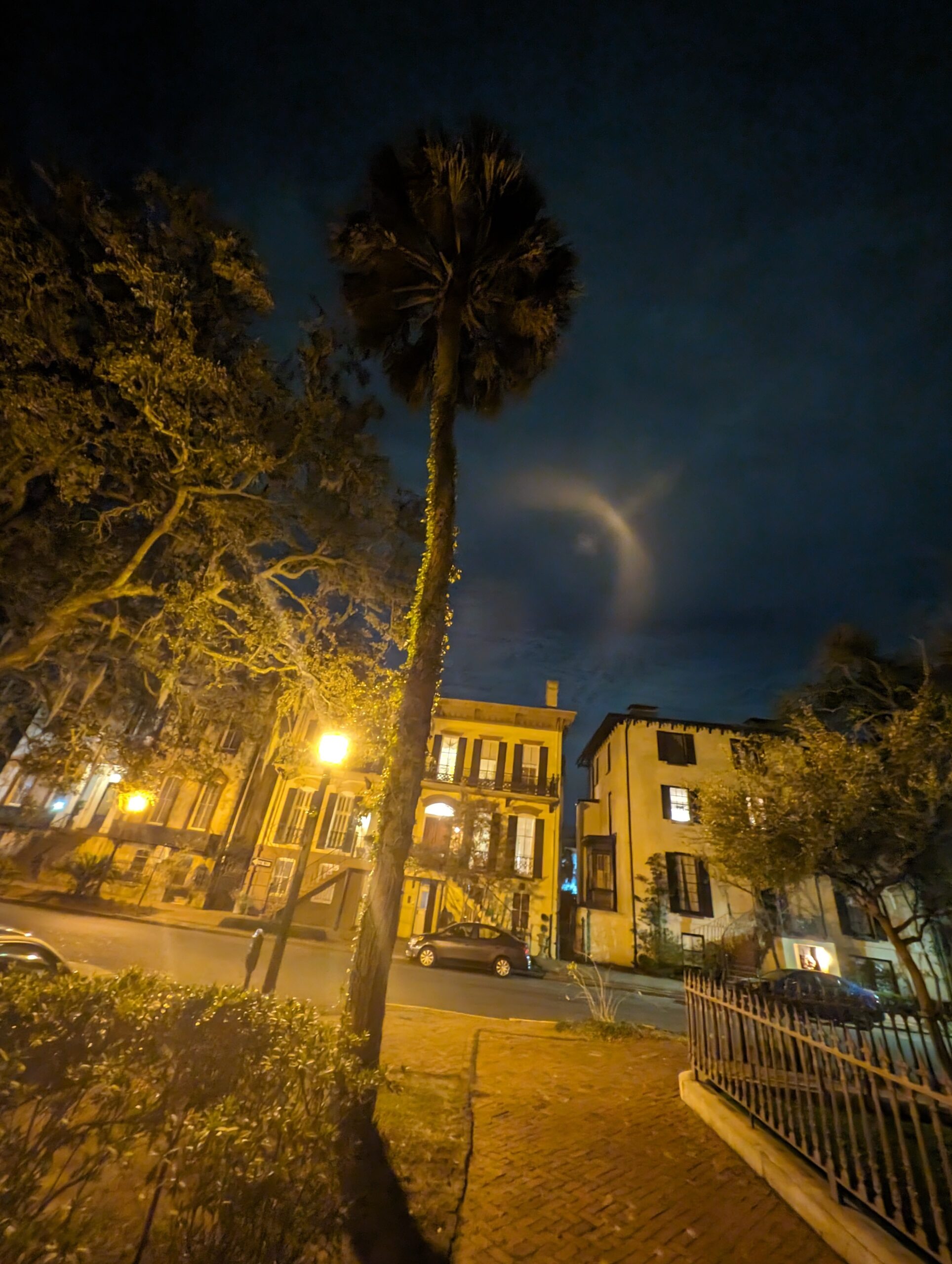 Savannah Georgia historic district at night with glowing street lamps and live oak trees