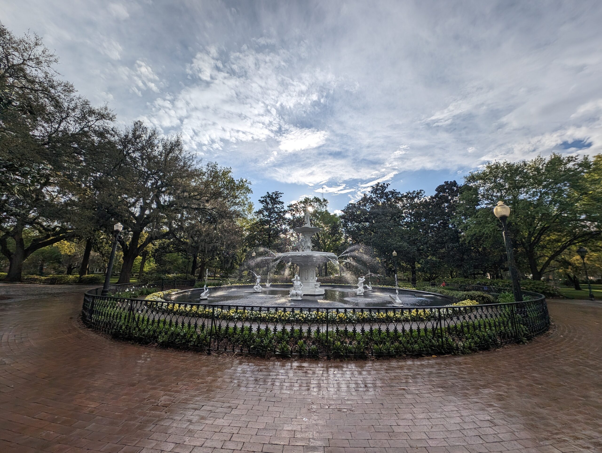 The Forsyth Park fountain in Savannah Georgia — wide angle view showing the cast iron fountain surrounded by live oak trees