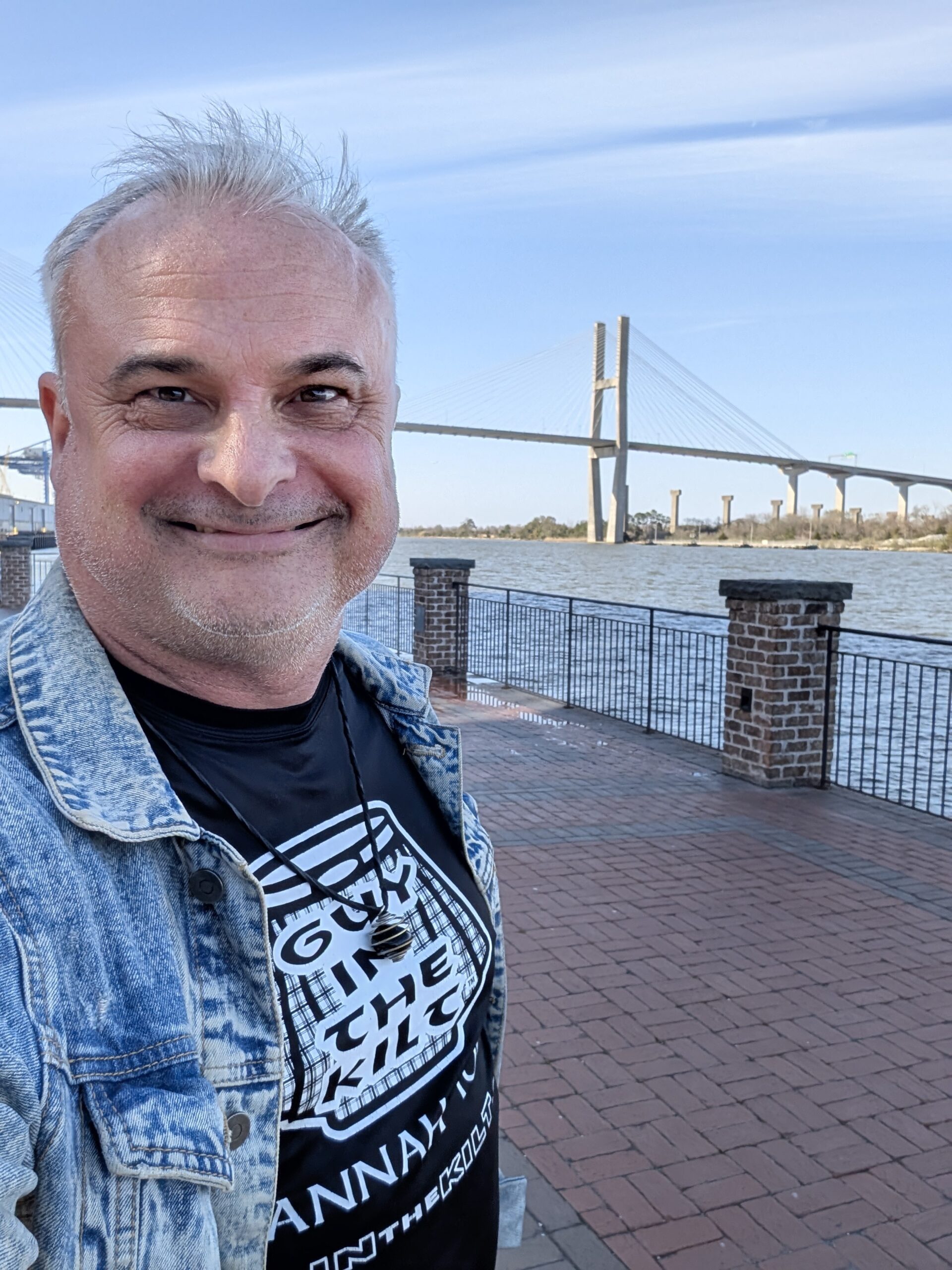 Patrick Burns Guy in the Kilt shirt at Savannah riverfront with Talmadge Memorial Bridge